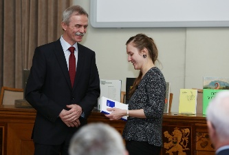 Daniela Poláková, vítězka 4. ročníku v kategorii <i>Humanitní a společenské vědy</i>, přebírá knihu <i>Marie Kudeříková</i> (20. března 2017).